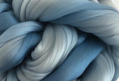 The primary subject of the image is a blue and white yarn, which is the main focus of the scene. The setting is a close-up of the yarn, showcasing its texture and colors. The visual style is a detailed, artistic representation of the yarn, possibly as a digital art or illustration. The dominant colors are blue and white, creating a calm and soothing atmosphere.