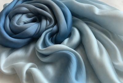 The primary subject of the image is a blue and white fabric, which is the main object, scene, or focus of the image. The setting is a white surface, and the visual style is a photo. The colors and mood of the image are predominantly blue and white, creating a calm and serene atmosphere.