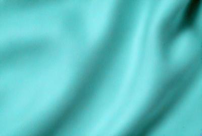 The primary subject of the image is a blue fabric, which appears to be a piece of cloth or a curtain. The setting is a room with a blue background, which complements the blue fabric. The visual style is a close-up of the blue fabric, showcasing its texture and color. The dominant colors in the image are blue, creating a calm and soothing atmosphere.