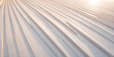 The primary subject of the image is a wooden surface with a pattern of slats or strips. The setting is a room with a wooden floor, and the visual style appears to be a photo of the wooden surface. The colors and mood of the image are predominantly neutral, with the wooden surface being the main focus.