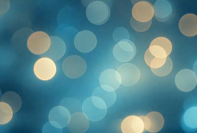 The primary subject of the image is a blue background with a pattern of white lights. The setting appears to be a nighttime cityscape, with the lights creating a vibrant and lively atmosphere. The visual style of the image is a combination of photo and digital art, as it captures the essence of a city at night with the lights creating a dynamic and engaging scene. The colors and mood of the image are predominantly blue and white, with the white lights adding a sense of brightness and energy to the