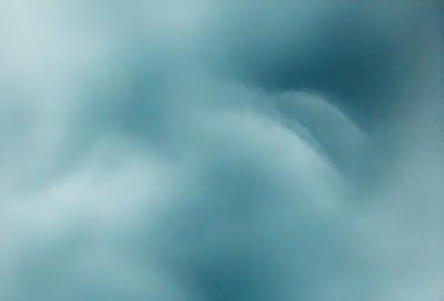 The primary subject of the image is a cloudy sky. The setting is a blue cloudy sky, which creates a moody atmosphere. The visual style is a photo, capturing the beauty of the cloudy sky. The colors and mood are predominantly blue, with the clouds adding depth and texture to the scene.