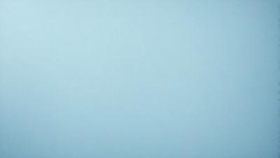 The primary subject of the image is a large, empty blue sky. The setting is a vast, open space with no visible landmarks or objects. The visual style is a natural, untouched landscape. The colors and mood are predominantly blue, creating a calm and serene atmosphere.