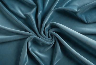 The primary subject of the image is a blue fabric, which appears to be a piece of cloth or a curtain. The setting is a room with a blue background, which complements the blue fabric. The visual style is a close-up of the fabric, showcasing its texture and details. The colors and mood of the image are predominantly blue, creating a calm and serene atmosphere.