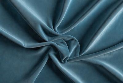 The primary subject of the image is a blue fabric, which is the main object, scene, or focus of the image. The setting or background is a blue cloth, and the visual style is a photo. The dominant colors and overall atmosphere are blue and dark, creating a moody and dramatic scene.