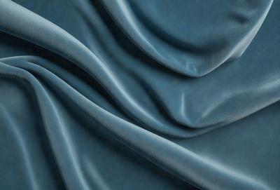 The primary subject of the image is a blue fabric, which appears to be a piece of cloth or a curtain. The setting is a room with a blue background, which complements the blue fabric. The visual style is a close-up of the fabric, showcasing its texture and details. The colors and mood of the image are predominantly blue, creating a calm and serene atmosphere.