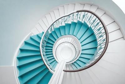The primary subject of the image is a spiral staircase with a blue and white color scheme. The staircase is made of metal and features a blue railing. The setting is a stairwell, and the visual style is a combination of photo and digital art. The colors and mood of the image are predominantly blue and white, creating a sense of elegance and sophistication.
