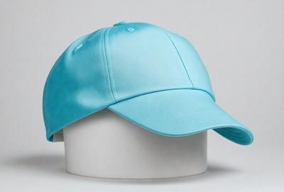 The primary subject of the image is a blue hat. The hat is placed on a white surface, which serves as the background. The visual style of the image is a close-up of the hat, showcasing its color and texture. The dominant colors in the image are blue and white, creating a calm and soothing atmosphere.