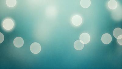 The primary subject of the image is a blue background with white circles scattered across it. The setting appears to be a dark room, and the visual style is a combination of a photo and digital art. The dominant colors are blue and white, creating a calm and serene atmosphere.