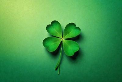 The primary subject of the image is a green four-leaf clover, which is placed on a green background. The visual style of the image is a photo, and the dominant colors are green, with a lime green hue. The overall atmosphere of the image is bright and fresh, with a focus on the four-leaf clover as the main object.