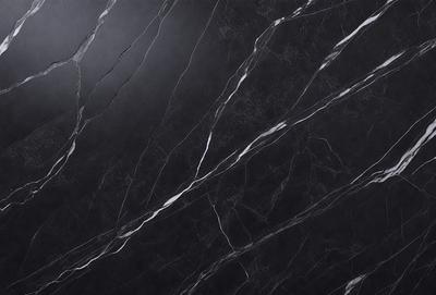 The primary subject of the image is a black marble countertop. The setting is a kitchen, with the countertop being the main focus of the scene. The visual style is a close-up of the marble countertop, showcasing its texture and pattern. The colors and mood of the image are predominantly dark, with the black marble countertop being the main source of contrast.