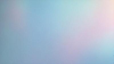 The primary subject of the image is a large, empty, and brightly lit room. The room is painted in a light blue color, giving it a calm and serene atmosphere. The setting is a white wall, which serves as the background for the room. The visual style of the image is a photo, capturing the room's emptiness and the bright lighting.