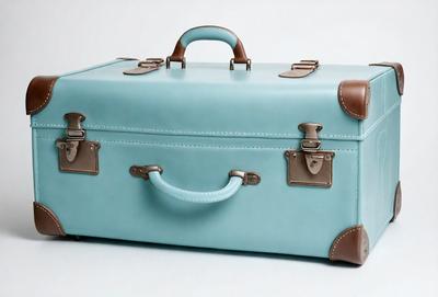 The primary subject of the image is a light blue suitcase. The setting is a white background, which provides a clean and minimalist appearance. The visual style is a photo, capturing the suitcase in its natural environment. The colors and mood of the image are predominantly light blue and calm, creating a sense of tranquility and relaxation.