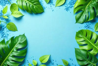 The primary subject of the image is a blue background with green leaves surrounding it. The leaves are scattered across the background, creating a visually appealing and natural scene. The setting appears to be a tropical or jungle-like environment, with the blue background providing a contrasting color to the green leaves. The visual style of the image is a combination of photo and digital art, as it captures the beauty of the green leaves and the blue background. The colors and mood of the image are vibrant and lively, ev