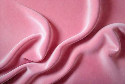 The primary subject of the image is a pink fabric, which is the main object, scene, or focus of the image. The setting or background is a pink surface, and the visual style is a close-up of the fabric. The colors and mood of the image are predominantly pink, creating a warm and inviting atmosphere.