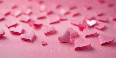 The primary subject of the image is a collection of pink hearts. The hearts are scattered across a pink surface, creating a visually appealing and romantic scene. The setting appears to be a pink background, which adds to the overall mood of the image. The visual style of the image is a combination of photo and digital art, as the hearts are arranged in a way that resembles a painting or drawing. The colors and mood of the image are predominantly pink, which evokes feelings of love,