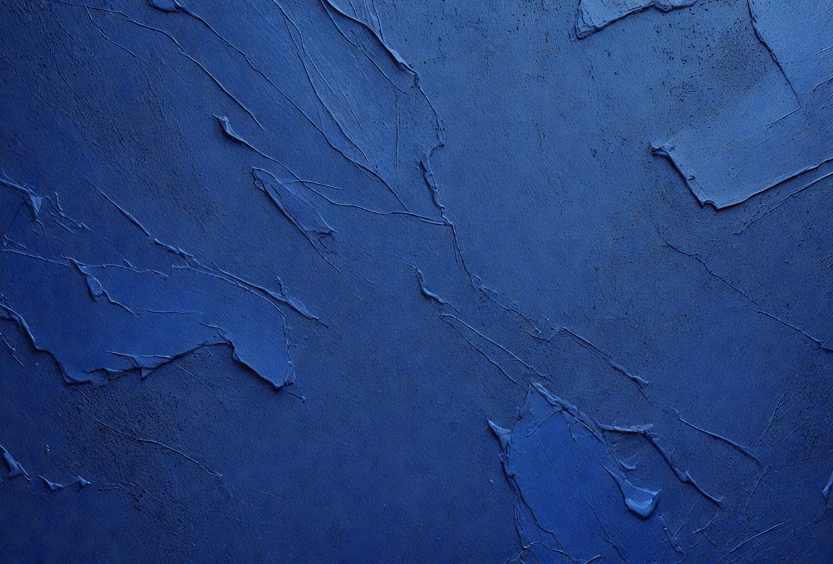 The primary subject of the image is a blue wall with a textured surface. The setting is a room with a blue wall, and the visual style is a close-up of the wall. The dominant colors are blue and grey, creating a calm and soothing atmosphere.