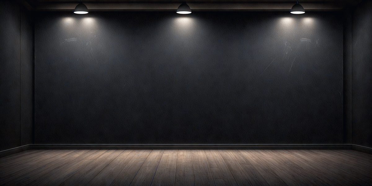 The primary subject of the image is a large, dark room with a black wall. The setting is a room with a wooden floor, and the visual style is a black and white photo. The dominant colors are black and white, creating a moody atmosphere.