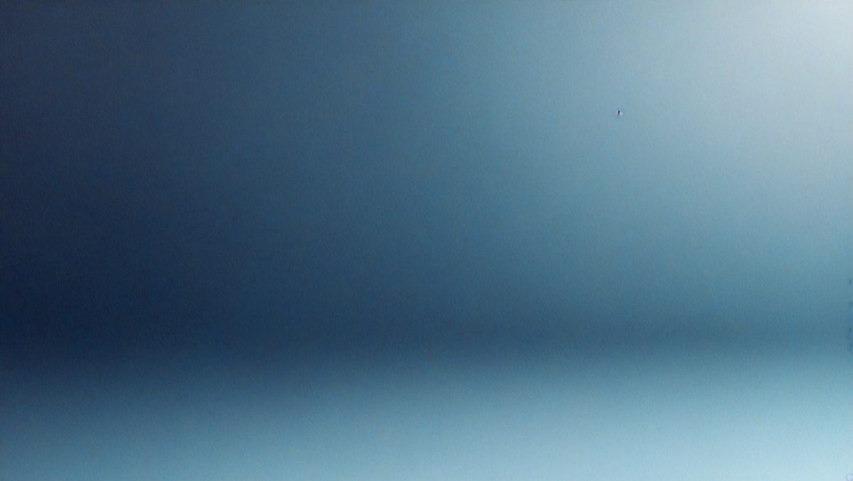 The primary subject of the image is a blue sky with a few clouds. The setting is a clear day with no visible landmarks or objects. The visual style is a natural, outdoor scene. The colors and mood are predominantly blue and calm, creating a serene atmosphere.