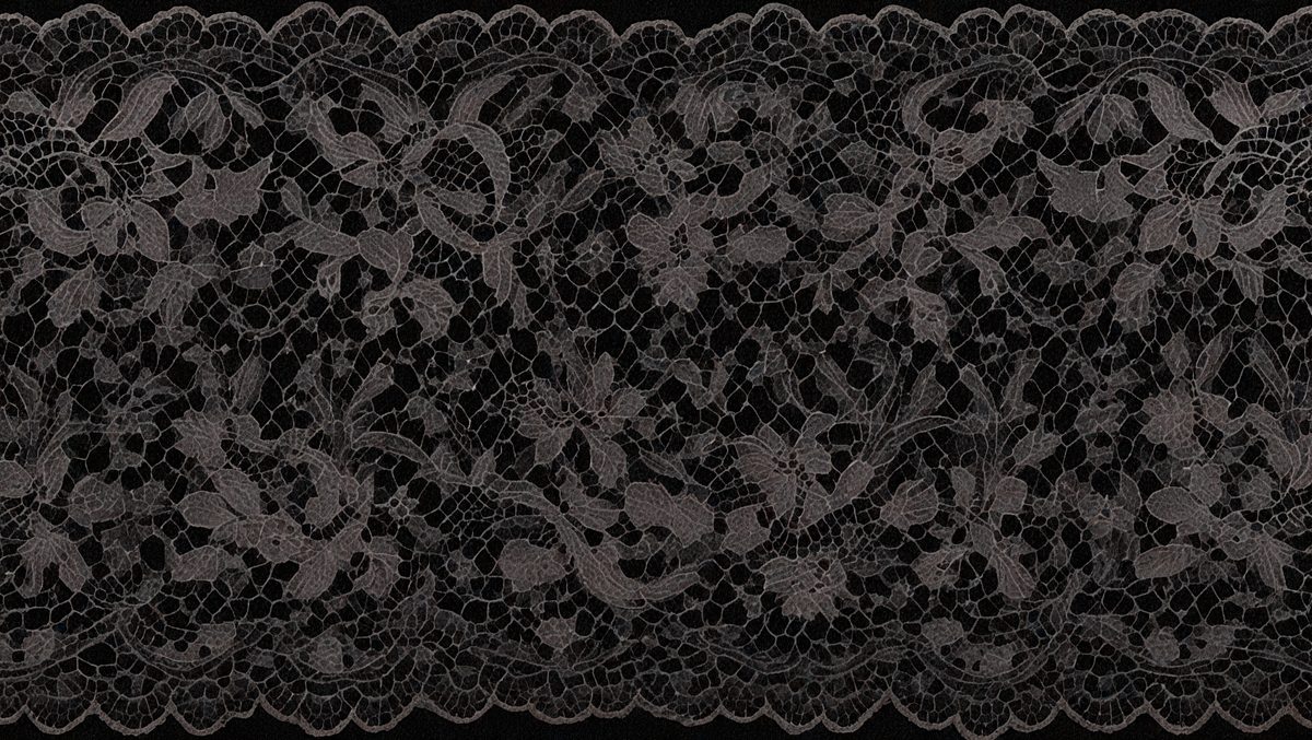 The primary subject of the image is a black and white lace pattern. The setting is a black background, which contrasts with the lace pattern. The visual style is a close-up of the lace pattern, showcasing its intricate details. The colors and mood of the image are predominantly dark and moody, with the lace pattern serving as the focal point.