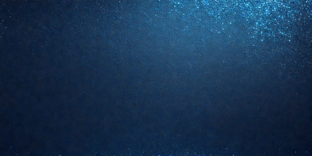 The primary subject of the image is a large, dark blue surface. The setting is a dark blue background, and the visual style is a close-up of the blue surface. The colors and mood of the image are predominantly dark and moody, with the blue surface being the main focus.