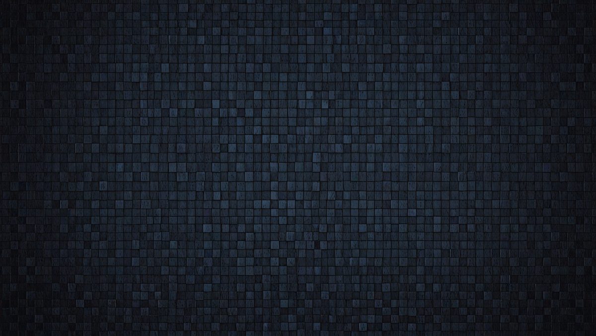 The primary subject of the image is a large, dark blue brick wall. The setting is a dark room, and the visual style is a close-up of the brick wall. The colors and mood of the image are predominantly dark and moody, with the blue bricks creating a sense of depth and texture.