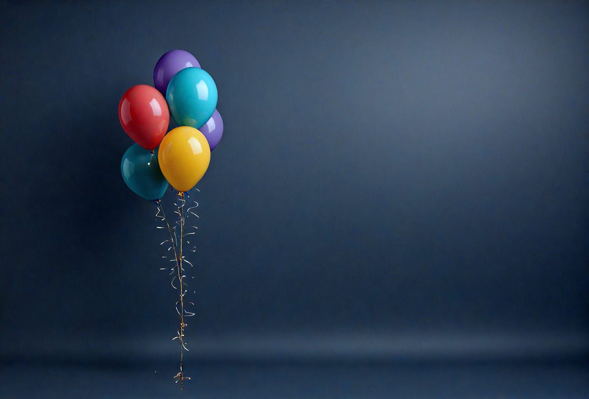 The primary subject of the image is a colorful balloon with a gold ribbon, which is floating in the air. The balloon is positioned in front of a blue background, creating a contrasting and visually appealing scene. The visual style of the image is a photo, capturing the balloon in its natural environment. The colors and mood of the image are vibrant and lively, with the balloon's vivid colors and the blue background creating a sense of fun and excitement.