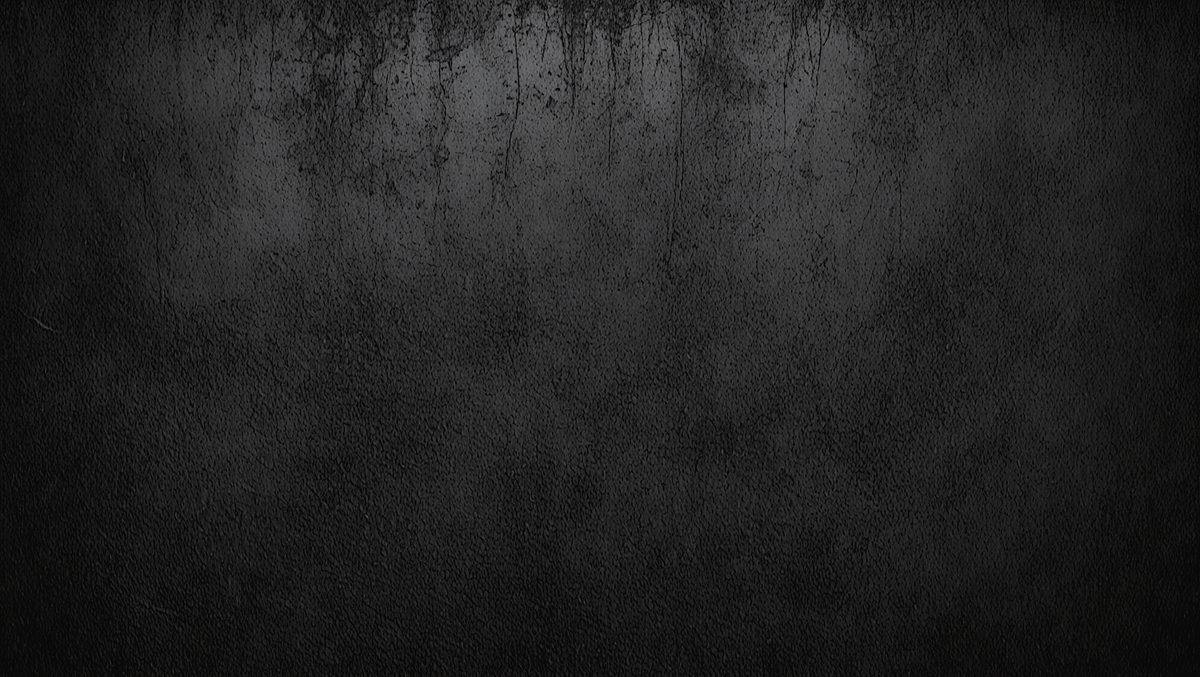 The primary subject of the image is a black and white photo of a wall. The setting is a dark room with a black background. The visual style is a black and white photo, which gives the image a classic and timeless appearance. The colors and mood are predominantly dark and moody, with the black and white tones adding to the overall atmosphere.
