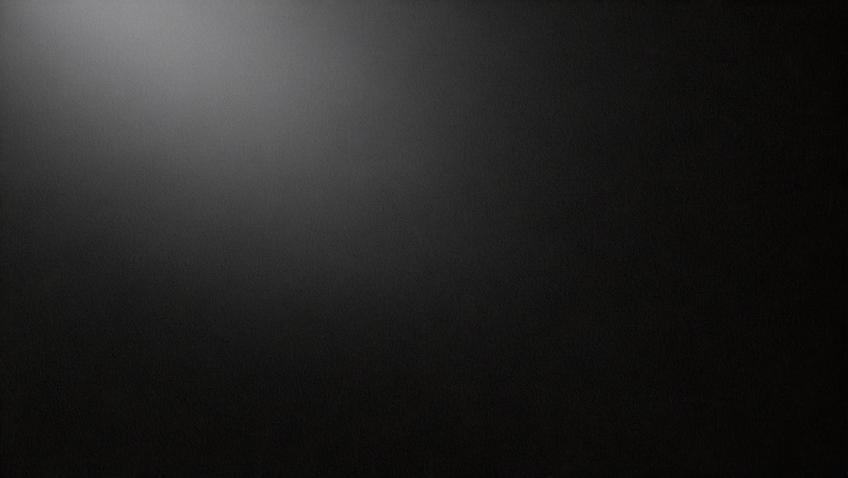 The primary subject of the image is a black background with a white light source. The setting is a dark room, and the visual style is a black and white photo. The colors and mood of the image are predominantly dark and moody, with the white light source creating a stark contrast against the black background.