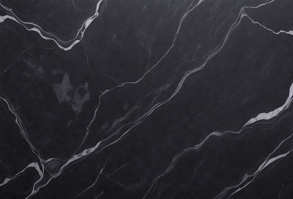 The primary subject of the image is a black marble countertop. The setting is a kitchen, with the countertop being the main focus of the scene. The visual style is a close-up of the marble countertop, showcasing its texture and pattern. The colors and mood of the image are predominantly dark, with the black marble countertop being the main source of contrast.