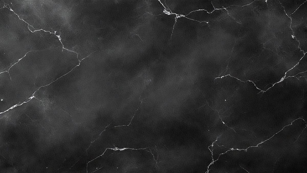 The image is a black and white photo of a marble surface, possibly a countertop or a wall. The marble surface has a pattern of holes, giving it a unique and textured appearance. The overall atmosphere of the image is dark and moody, with the black and white color scheme adding to the dramatic effect.